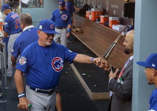 Chicago Cubs manager Joe Madden bumps fists with team official before playing the Los Angeles Dodgers in game 1 of the NLCS at Dodgers Stadium in Los Angeles on October 14, 2017. Photo by Jim Ruymen\/