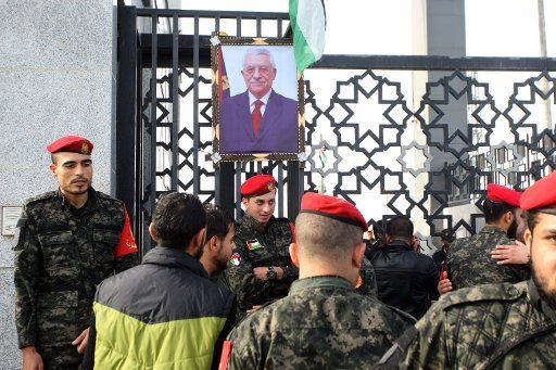 Palestinian security forces loyal to Hamas stand next to a portrait of Palestinian president Mahmoud Abbas outside the Rafah border crossing with Egypt that is now under the control of the Palestinian Authority, in the southern Gaza Strip on ...