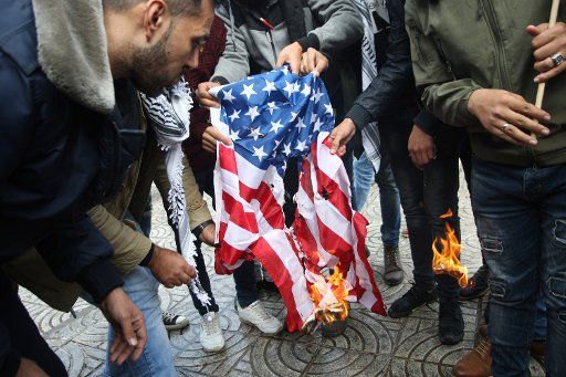 Palestinian protesters burn the US flag during a protest against US President Donald Trump in Gaza City on December 6, 2017. President Donald Trump is set to recognize Jerusalem as Israel\