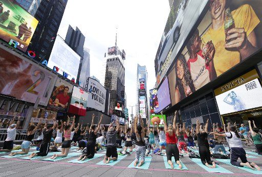 People participate in yoga classes in Times Square to celebrate the Summer Solstice on the first day of Summer in New York City on June 21, 2017. Thousands of yogis will participate in eight yoga classes during the 15th annual Solstice in Times Square. Photo by John Angelillo\/
