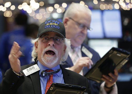 A trader wearing a DOW ALMOST 20,000 hat works on the floor of the NYSE at the closing bell on at the New York Stock Exchange on Wall Street in New York City on January 6, 2017. The Dow Jones Industrial Average is approaching the 20,000 mark for the first time in history. Photo by John Angelillo\/