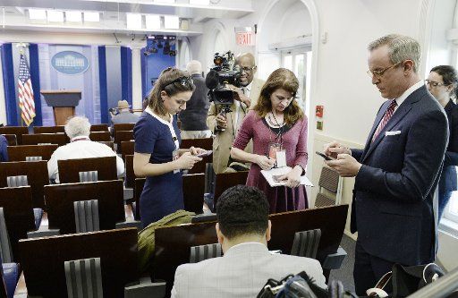 Reporters stand in the press briefing room of the White House after being excluded from the meeting on February 24, 2017 in Washington, D.C. CNN and other news organizations were blocked Friday from a White House press briefing. Pool photo by Olivier Douliery\/