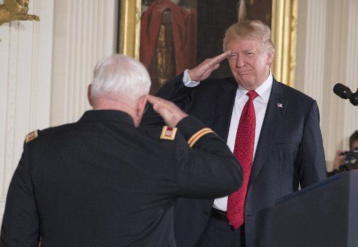 U.S. President Donald Trump salutes Medal of Honor recipient Retired Army Capt. Gary Michael Rose during ceremony in the East Room of the White House in Washington, D.C., on October 23, 2017. Rose was a special forces medic who saved numerous lives on a secret mission to Laos during the Vietnam War. Photo by Pat Benic\/