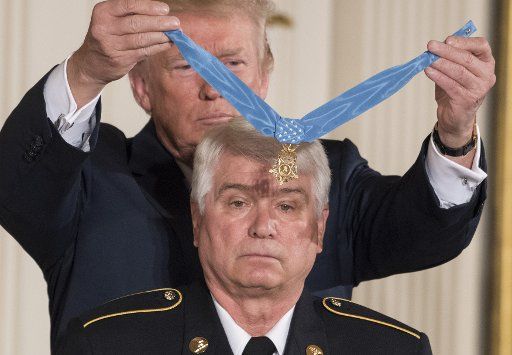 U.S. President Donald Trump awards the Medal of Honor to James McCloughan during a ceremony in the East Room of the White House in Washington, D.C., on July 31, 2017. McCloughan was an U.S. Army medic who rescued 10 of his comrades from a kill zone during the 1969 Battle of Hui Yon Hill in Vietnam. Photo by Pat Benic\/