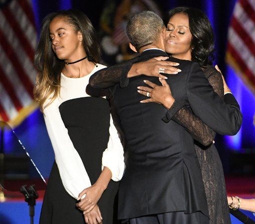 Michelle Obama (R-L) hugs her husband U.S. President Barack Obama as they stand on stage with daughter Malia after the President delivered his farewell address to a crowd of supporters at McCormick Place in Chicago on January 10, 2017. Photo by David Banks\/