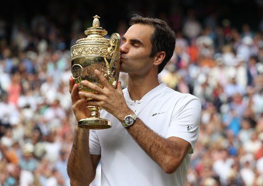Swiss Roger Federer kisses the Wimbledon Singles trophy after victory over Croat Marin Cilic at the 2017 Wimbledon championships, London on July 16, 2017. Federer beat Cilic 6-3, 6-1, 6-4, to win his eighth Wimbledon Men\