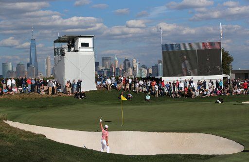 Justin Thomas of the United States reacts as his putt from the bunker on the 14th green goes in the hole on day two of the Presidents Cup on September 29, 2017 at Liberty National Golf Club in Jersey City, New Jersey. Photo by Rich Schultz\/