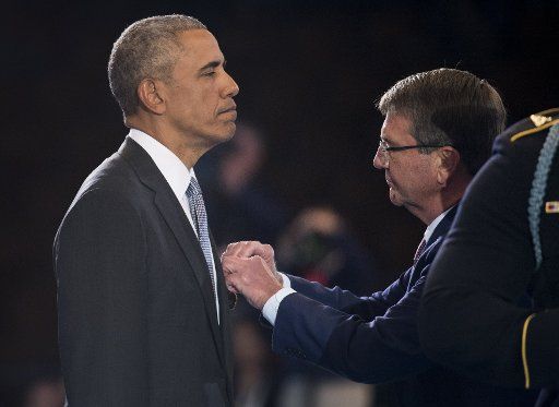 President Barack Obama receives a service medal from Secretary of Defense Ashton Carter during his Armed Forces Full Honor Review Farewell Ceremony at Joint Base Myers-Henderson Hall, in Virginia on January 4, 2017. The five braces of the military honored the president and vice-president for their service as they conclude their final term in office. Photo by Kevin Dietsch\/
