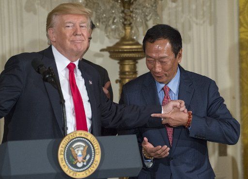U.S. President Donald Trump shakes hands with Foxconn Chairman Terry Gou, who bows, during event in the East Room of the White House in Washington, D.C., on July 26, 2017. Foxconn will make an investment of $10 billion for a LCD plant in Wisconsin that will create thousands of jobs. Photo by Pat Benic\/