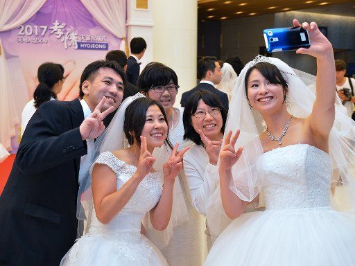 Newly married couples takes pictures before the Blessing Ceremony of the Family Federation for World Peace and Unification at the CheongShim Peace World Center in Gapyeong, South Korea, on September 7, 2017. Photo by Keizo Mori\/
