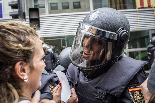 Spanish police officers prevent people from entering a polling station in Barcelona, on October 1, 2017, on the day of a referendum on independence for Catalonia banned by Madrid. More than 5.3 million Catalans are called today to vote in a referendum on independence. photo by Angel Garcia\/