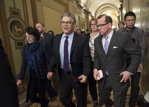Sen. Al Franken (C), D-MN, joined by his wife Franni, walks to the Senate Chambers to deliver his resignation speech, at the U.S. Capitol on December 7, 2017 in Washington, D.C. Franken is resigning in the wake of several sexual misconduct allegations, some of which he is denying. Photo by Kevin Dietsch\/