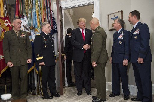 President Donald Trump greets military officials as he arrives to sign H.R. 2810, the National Defense Authorization Act for Fiscal Year 2018, during a signing ceremony in the Roosevelt Room on December 12, 2017 in Washington, D.C. Photo by Kevin Dietsch\/