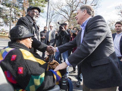 Democratic Senatorial candidate Doug Jones greets supporters as he campaigns outside the polls on December 12, 2017 in Birmingham, Alabama. Jones is trying to defeat the Republican candidate Judge Roy Moore in the special Senate election. Photo by Mark Wallheiser\/