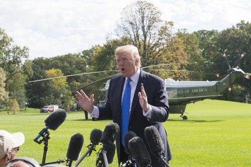 U.S. President Donald Trump answers a reporters question during an impromptu press conference on the South Lawn as he walks from the Oval Office to Marine One to depart the White House in Washington, DC on October 25, 2017. The president answered a ...