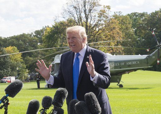 U.S. President Donald Trump answers a reporters question during an impromptu press conference on the South Lawn as he walks from the Oval Office to Marine One to depart the White House in Washington, DC on October 25, 2017. The president answered a ...
