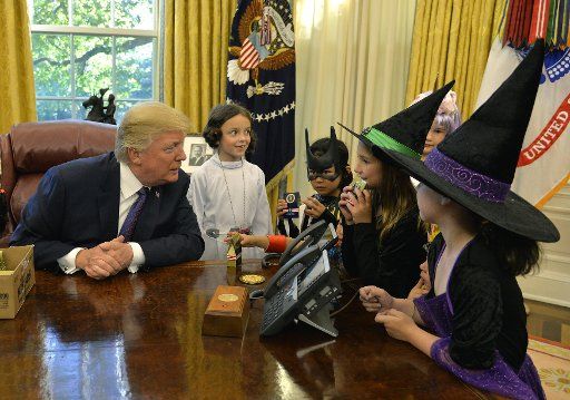 President Donald Trump welcomes children in Halloween costumes to the Oval Office of the White House, October 27, 2017, in Washington, DC. Trump and First Lady Melania Trump will welcome children of the military to the White House next week for ...
