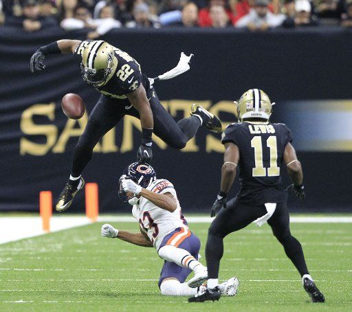 New Orleans Saints running back Mark Ingram (22) loses the ball momentarily while hurdling Chicago Bears cornerback Kyle Fuller (23) as wide receiver Corey Fuller (11) looks on during the second quarter at the Mercedes-Benz Superdome in New Orleans ...