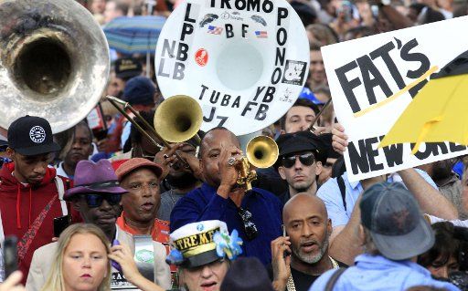 Trumpeter James Andrews, center in dark blue, leads a second-line parade for the late music legend Fats Domino through the Bywater neighborhood of New Orleans, November 1, 2017. Domino passed away last week at the age of 89. Photo by AJ Sisco\/