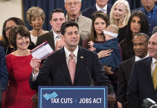 Speaker of the House Paul Ryan, R-WI, holds a sample tax form as he unveils the Republican\