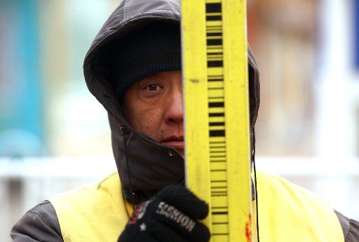 A member of a road surveying crew holds a measurement pole in Beijing on January 27, 2018. One of the key factors in China\