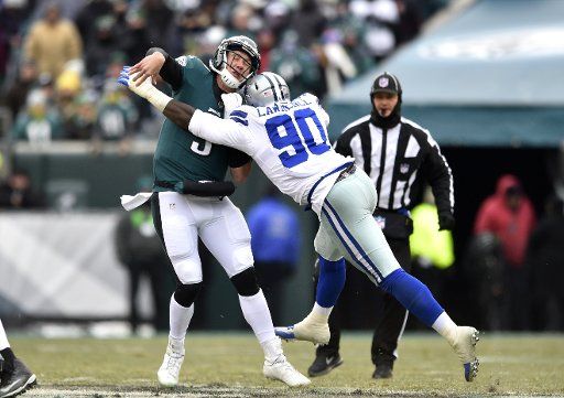 Philadelphia Eagles quarterback Nick Foles (9) is hit as he throws by Dallas Cowboys defensive end DeMarcus Lawrence (90) at Lincoln Financial Field on December 31, 2017 in Philadelphia. Photo by Derik Hamilton\/