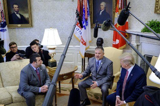 Shane Bouvet, left, and President Donald Trump listen as Don Bouvet, tells the assembled media how President Trump gave $10,000 to his son, to help pay for his father\