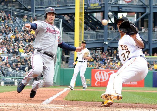 Minnesota Twins first baseman Joe Mauer (7) slides into home safe under the tag of Pittsburgh Pirates relief pitcher Edgar Santana (37) in the top of the sixth inning on Opening Day at PNC Park on April 2, 2018 in Pittsburgh. Photo by Archie Carpenter\/