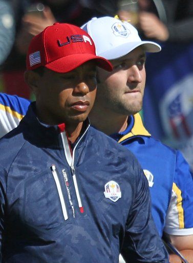 Tiger Woods (L) and Jon Rahm leave the 1st tee on the final day of competition of the Ryder Cup at Le Golf National in Guyancourt near Paris on September 30, 2018. Team Europe leads Team USA 10-6 heading into the final day of competition. Photo by David Silpa\/