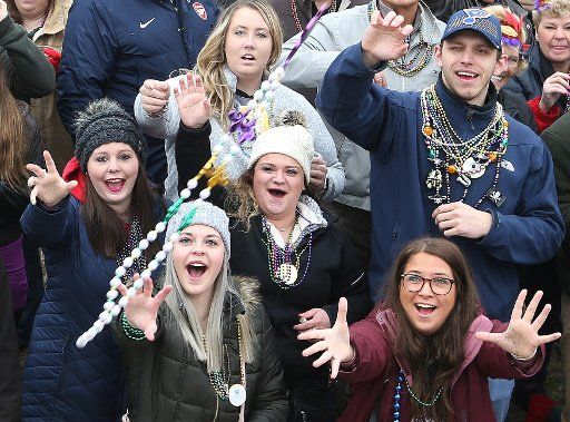Party goers along the parade route wait as beads are thrown from a passing float during the 40th Mardi Gras Parade in St. Louis on March 3, 2019. Photo by Bill Greenblatt\/