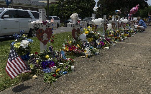 A woman visits a memorial near the scene of a mass shooting where 12 people were killed, in Virginia Beach, Virginia on June 3, 2019. At least 12 people are dead and four wounded after a disgruntled employee opened fire at a Virginia Beach municipal center on March 31. Photo by Ray Stubblebine\/
