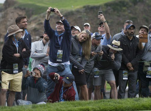 Golf fans watch Tiger Woods tee off on the 14th hole on day one at the U.S. Open in Pebble Beach, California on June 13, 2019. Photo by Terry Schmitt\/