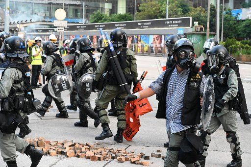 Riot police wearing gas masks gather to disperse crowds in a tense day of violence in Hong Kong on Sunday, September 15, 2019. Photo by Thomas Maresca\/