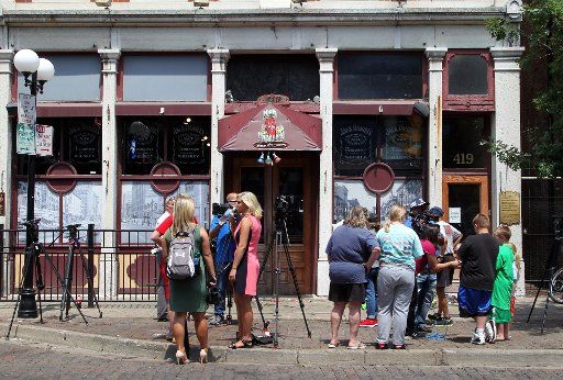 Members of the media and mourners stand outside the doors of Ned Peppers bar, the site of a mass shooting, Monday, August 5, 2019 in Dayton, Ohio. Photo by John Sommers II\/