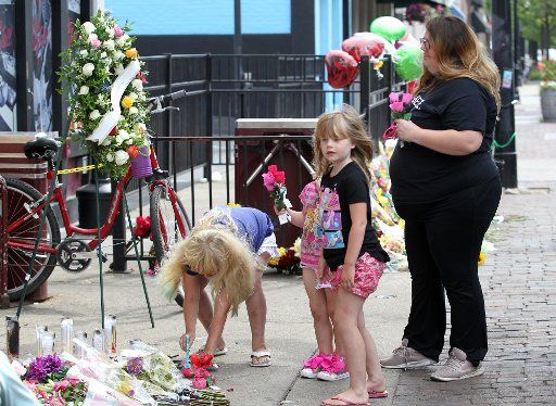 Mourners pay their respect to the nine victims killed outside the doors of Ned Peppers bar, the site of a mass shooting, Monday, August 6, 2019 in Dayton, Ohio. Photo by John Sommers II\/