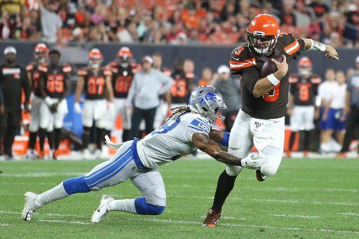 Cleveland Browns Garrett Gilbert is taken down by Detroit Lions Mike Ford Thursday in Cleveland, Ohio on August 29, 2019. Photo by Aaron Josefczyk\/