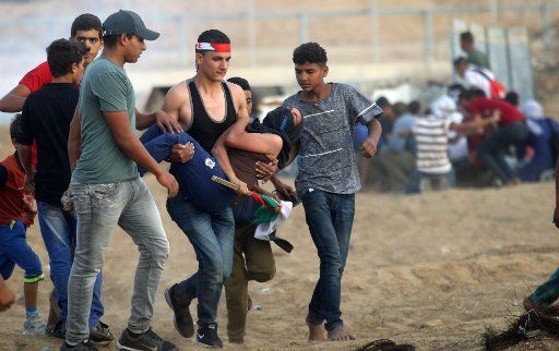 A wounded Palestinian protester is evacuated during clashes with Israeli forces following a demonstration along the border with Israel east of Khan Yunis in the southern Gaza strip on Friday on October 25, 2019. 77 Palestinians wounded, by the Israeli army. a medical source said. Photo by Ismael Mohamad\/UPI.
