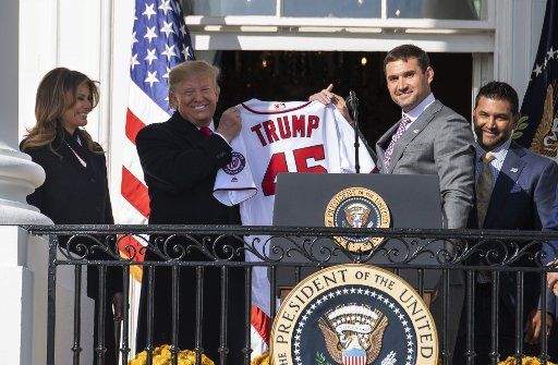 Washington Nationals first baseman Ryan Zimmerman gives President Donald Trump a jersey as Trump welcomes the 2019 World Series champion Washington Nationals on the Truman Balcony at the White House on Monday, November 4, 2019. First lady Melania Trump (L) and Nationals Manager Dave Martinez look on Photo by Pat Benic\/UPI.
