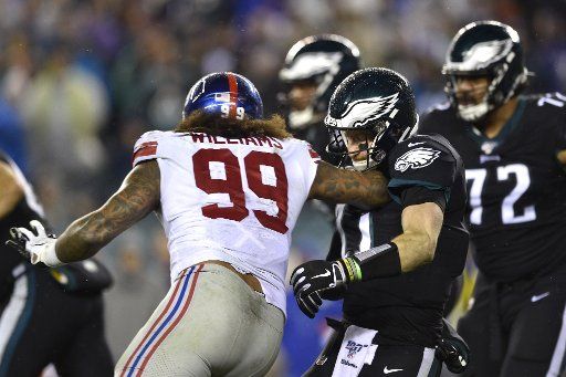 Philadelphia Eagles quarterback Carson Wentz (11) takes a hit from New York Giants defensive end Leonard Williams (99) during the second half at Lincoln Financial Field in Philadelphia on Monday, December 9, 2019. The Eagles won 23-17. Photo by Derik Hamilton\/