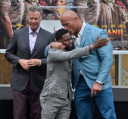Actors Will Ferrell (L) and Dwayne Johnson (R) join Kevin Hart (C) during a hand and footprint ceremony immortalizing Hart in the forecourt of the TCL Chinese Theatre (formerly Grauman\