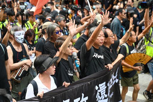 Former politician Lee Cheuk-yan and other politicians and activists hold up five fingers to signify the five demands of their protest movement in Hong Kong on October 1, 2019. Photo by Thomas Maresca\/