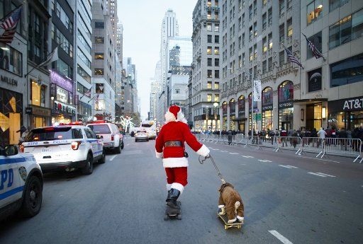 A man dressed as Christmas Santa Claus skateboards down 5th Avenue with a dog also on a skateboard before the 87th annual Christmas Tree Lighting Ceremony at Rockefeller Center in New York City on Wednesday, December 4, 2019. Photo by John Angelillo\/