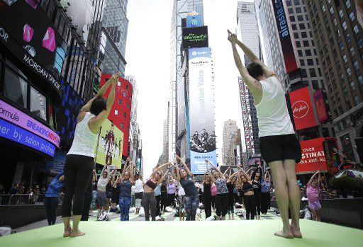 People participate in yoga classes in Times Square to celebrate the Summer Solstice on the first day of Summer in New York City on June 21, 2019. Thousands of yogis will participate in eight yoga classes during the 16th annual Solstice in Times Square. Photo by John Angelillo\/