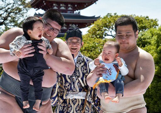 A baby held by an amateur sumo wrestler cries during the "baby crying contest (Naki Sumo)" at the Sensoji temple in Tokyo, Japan, on April 28, 2019. This contest takes place for parents wishing good health and strength for children since 1986. Photo by Keizo Mori\/