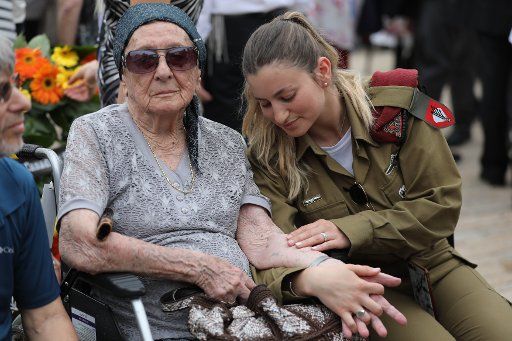 Israeli soldier Shira Tessler holds the hand of her grandmother, Holocaust survivor Hanna Tessler during a ceremony marking the annual Holocaust Remembrance Day at Yad Vashem Holocaust Memorial in Jerusalem, Israel, on May 2, 2019. Israel comes to a complete standstill across the country as the siren sounds honoring the six million Jews who perished at the hands of the Nazis during the Holocaust of World War II. Pool Photo by Abir Sultan\/