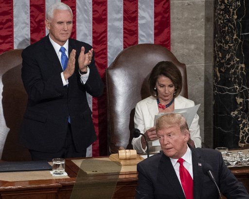 Speaker of the House Nancy Pelosi looks at papers as Vice President Mike Pence stands and applauds as President Donald Trump delivers his State of the Union address to a joint session of Congress in the House Chamber of the U.S. Capitol in Washington, D.C. on February 5, 2019. Photo by Pat Benic\/