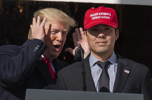 President Donald Trump smiles as Washington Nationals player Kurt Suzuki wears a "Make America Great Again" hat during a ceremony for the World Series Champions on the Truman Balcony at the White House on Monday, November 4, 2019. Photo by Pat Benic\/