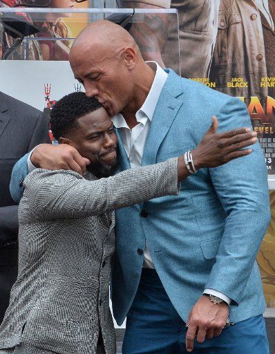 Actor Dwayne Johnson (R) joins Kevin Hart (C) during a hand and footprint ceremony immortalizing Hart in the forecourt of the TCL Chinese Theatre (formerly Grauman\