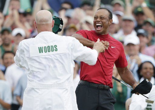Tiger Woods celebrates with caddie Joe LaCava on the 18th green in the final round at the 2019 Masters Tournament at Augusta National Golf Club in Augusta, Georgia, on April 14, 2019. Tiger Woods won The Masters with a score of 13 under par for his 5th Green Jacket. Photo by John Angelillo\/