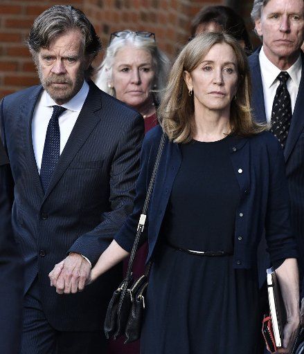 Actress Felicity Huffman, right, leaves her sentencing hearing with her husband William H. Macy, left, at the John Joseph Moakley United States Courthouse in Boston on Thursday, September 13, 2019. Huffman was sentenced to 14 days for her part in a sweeping college admissions bribery case. Photo by Josh Reynolds\/